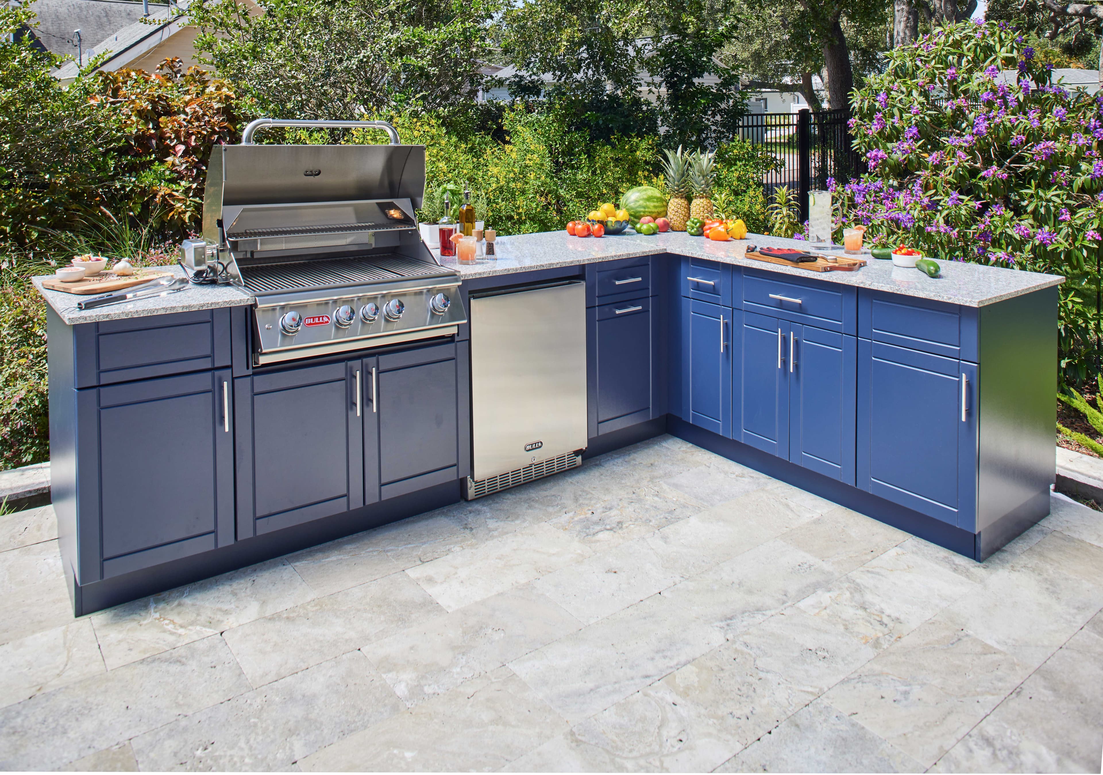Built-in Bull gas grill in an open-air outdoor kitchen on a stone patio