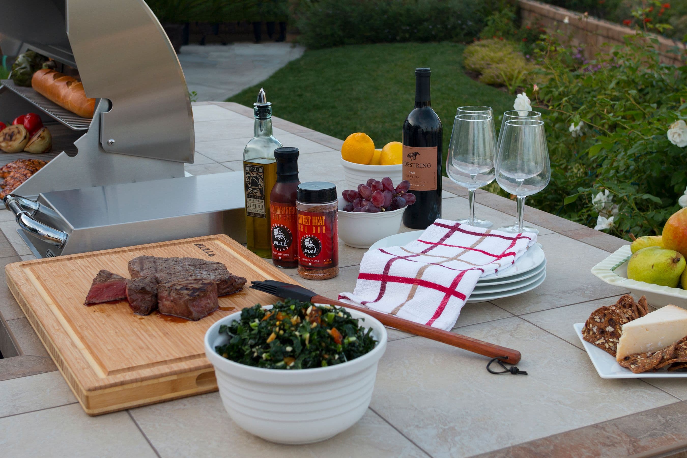 Backyard outdoor kitchen set for entertaining with food on grill