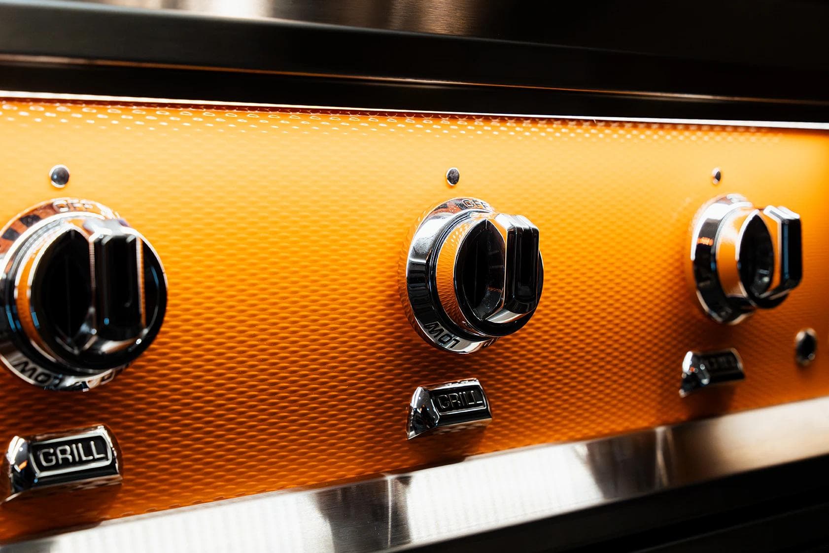 Hestan outdoor grill installed in a luxury outdoor kitchen with stone surround.